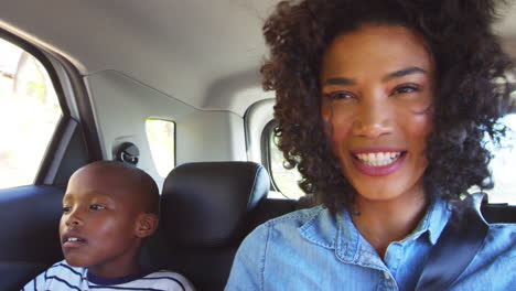 Una-Joven-Madre-Negra-Con-Un-Niño-En-Un-Coche-Yendo-De-Viaje-Por-Carretera