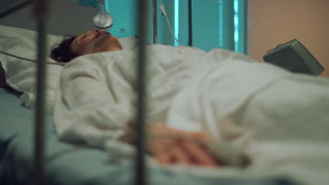 Patient-with-oxygen-mask-resting-in-hospital.-Pulse-oximeter-on-finger-closeup.