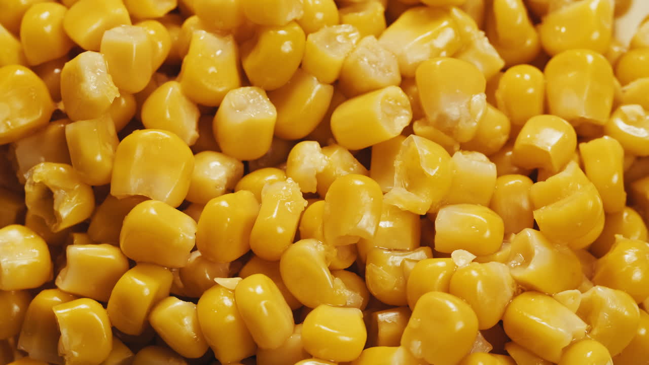 Canned corn rotating on dark background. Close up on opened aluminum can with corn. High quality 4k footage