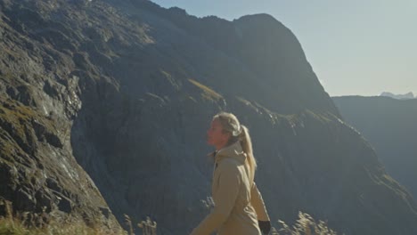 woman walking away from blissful view during hike in new zealand, gertrude