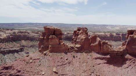 Amazing-Natural-Rock-Formation-atop-Sandstone-Butte-Cliffs-in-Moab,-Utah---Aerial-Flight