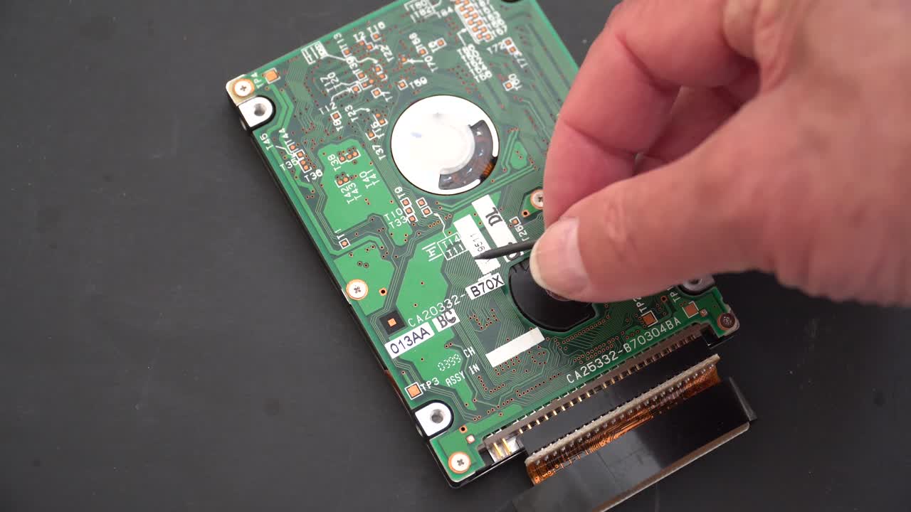 disco duro de la computadora siendo inspeccionado de cerca por un técnico