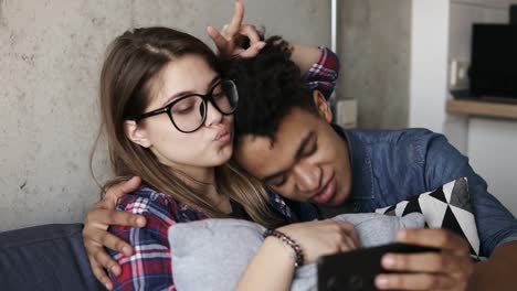 cute happy couple taking selfies on the couch.