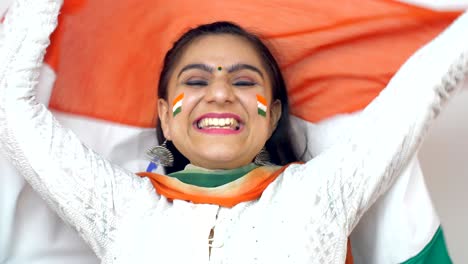 close shot of a beautiful indian woman proudly holding a national flag - independence day / republic day concept