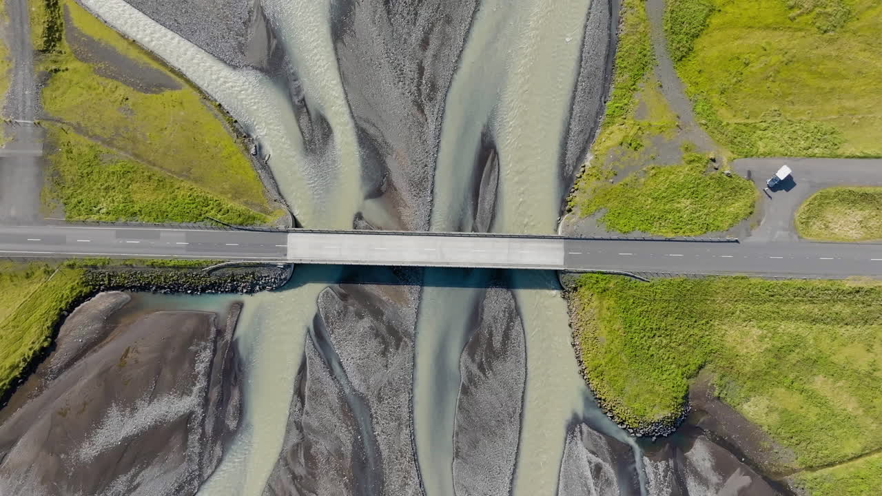 Birdseye drone shot descending above a bridge above a river delta in Iceland