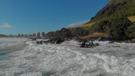 cámara lenta aérea: olas rompiendo sobre rocas clip 1