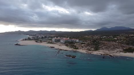 vista aérea sobre la hermosa costa de la playa de el chileno baja california sur, méxico con una vista del mar azul, edificios de hoteles y paisajes con vegetación exuberante con magníficas cadenas montañosas