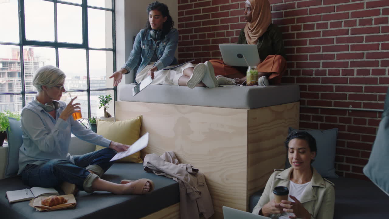 다양한 비즈니스 여성 팀이 창의적인 마케팅 전략을 논의하고 아이디어를 공유하고 스타트업 프로젝트를 함께 진행하며 태블릿 컴퓨터를 사용하여 현대 사무실 작업장에서 팀워크를 즐기고 있습니다.