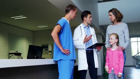 Doctors-discussing-over-clipboard