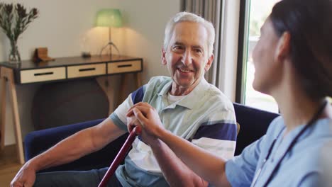 Animation-of-happy-caucasian-senior-man-with-walking-stick-talking-with-biracial-female-doctor