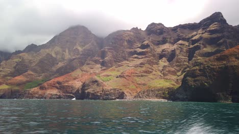 Toma-Panorámica-Panorámica-De-Cardán-Desde-Un-Barco-En-Movimiento-De-Las-Crestas-únicas-Y-Coloridas-A-Lo-Largo-De-La-Costa-De-Na-Pali-En-La-Isla-Hawaiana-De-Kaua&#39;i.