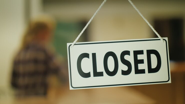 Venditore chiude il negozio a tarda sera. Concetto di lavoro notturno.