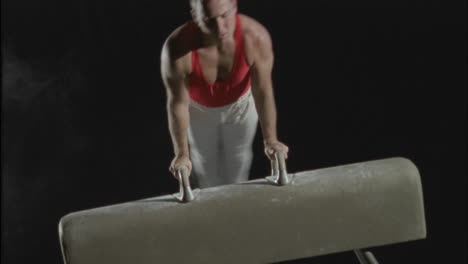 a gymnast performs flairs on the pommel horse