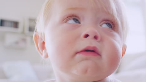 white toddler boy making face, reaching to camera, close up