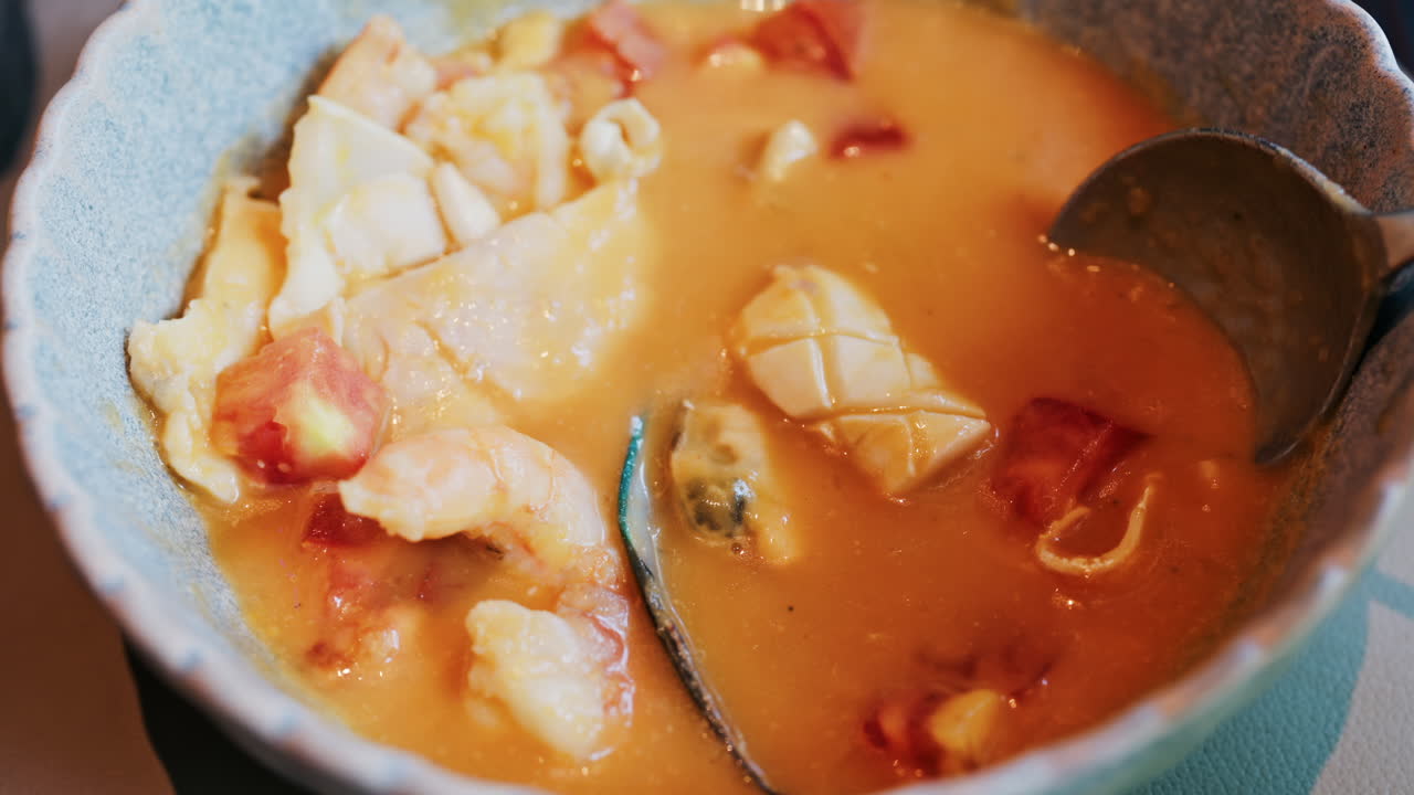 Close up of a creamy seafood stew with mussels, squid, and shrimp