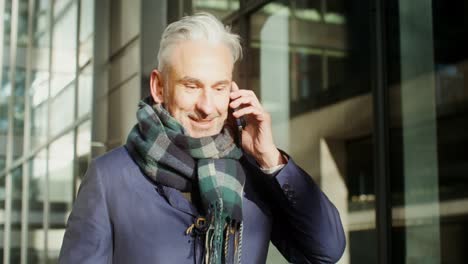 businessman talking on phone outside office building