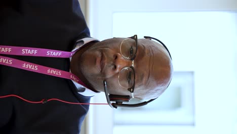 staff member in a call center provides customer service with a headset, phone, and lanyard badge, showcasing communication and professionalism