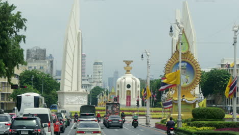 moving in a city traffic towards a roundabout and a famous landmark of democracy monument in the middle of bangkok, thailand.