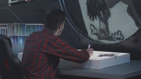 artist working on a drawing at a desk