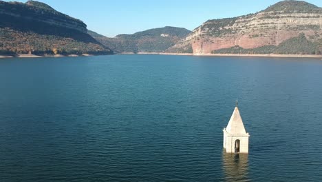 aerial views of sau reservoir in catalonia with a church in the middle