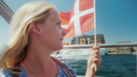 A-Tourist-With-The-Flag-Of-Denmark-Sails-On-A-Sightseeing-Boat-Through-The-City's-Canals