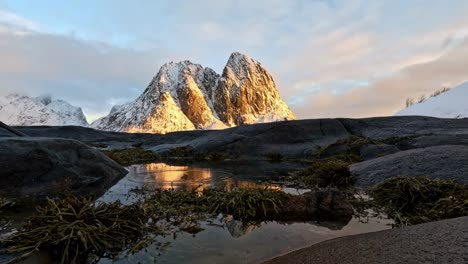 Isla-Olenils-Y-Olstinden-En-Reine-Lofoten-Al-Atardecer,-Pequeños-Anillos-Moviéndose-En-Espejo-Como-Agua