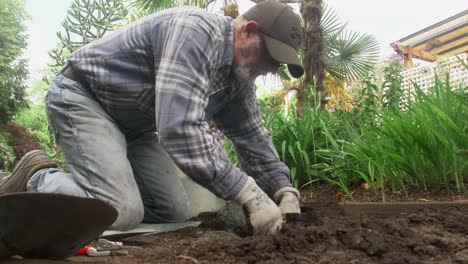 gardener installing sprinkler along botanical garden trail