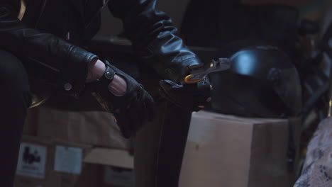 Criminal-with-black-leather-gloves-checking-wrench-and-dropping-it-in-the-duffle-bag