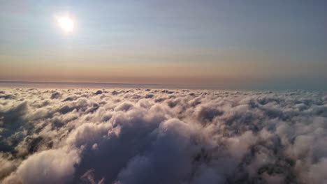 glowing sun above thick cloudscape, aerial view