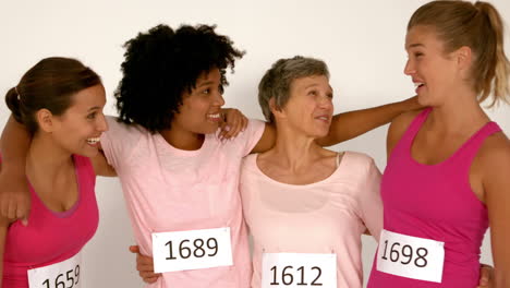 four smiling female athletes with arms around