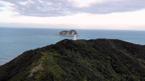 Faro-Del-Cabo-Este,-Hito-Histórico-En-La-Colina-Otiki-Con-Vistas-Al-Paisaje-Marino-En-La-Isla-Norte,-Nueva-Zelanda