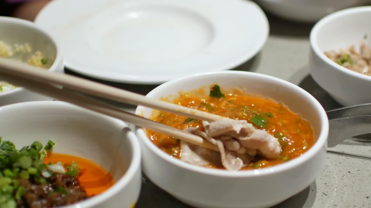 소스에 담그는 돼지 고기 조각 프론 핫팟 샤브샤브를 넣는 동안 4k 비디오 pov