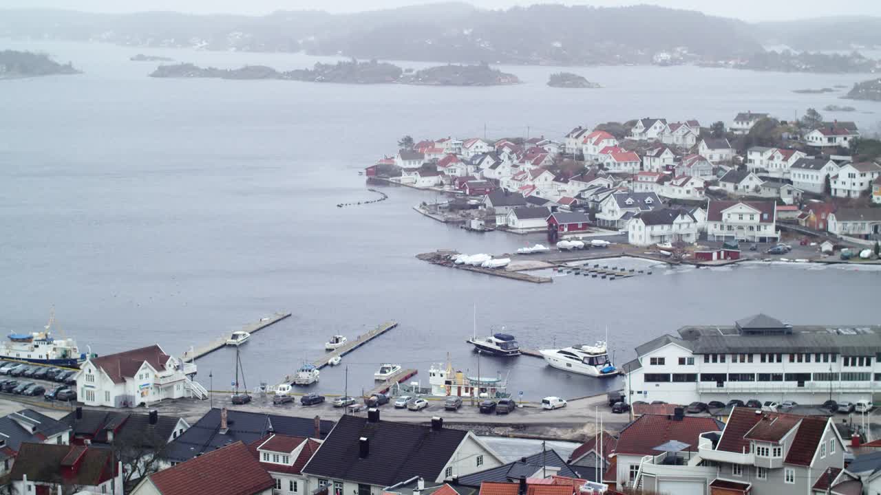 Panoramablick auf die Insel Øya vor der Küste von Kragerø im südöstlichen Norwegen an einem bewölkten Tag, mit nordischer Holzarchitektur, exklusiven Häusern und Wohngebieten mit mehreren Yachtanlegestellen.