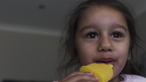 pequeña niña asiática de cuatro años comiendo polo de hielo