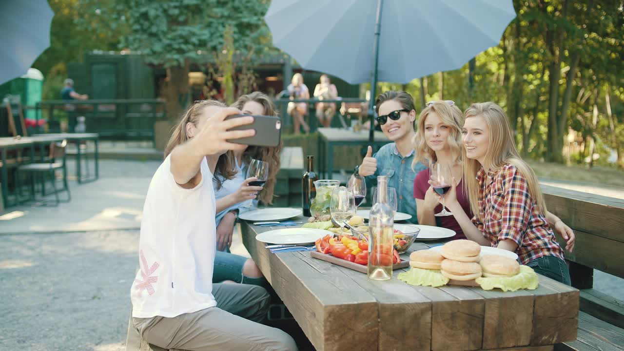 와인을 마시며 드폰으로 사진을 찍는 친구들.