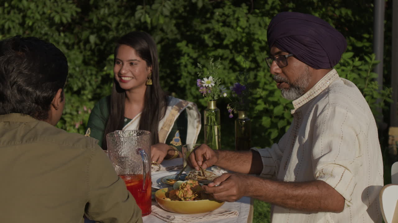 Indian Family and Friends Enjoying an Outdoor Meal Together