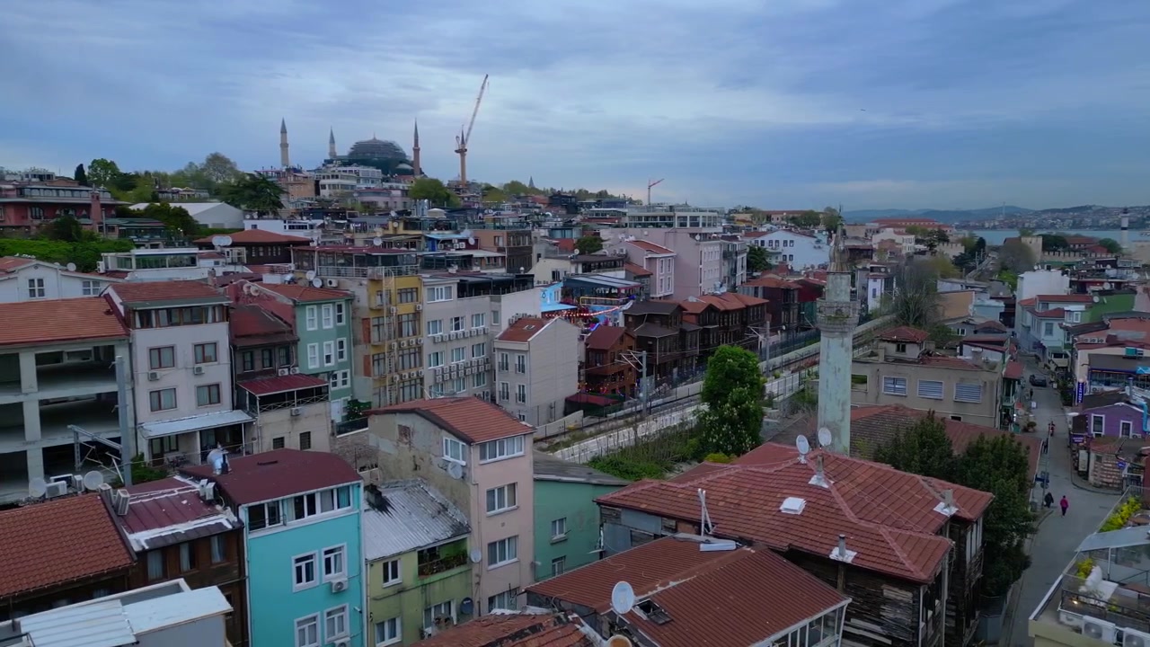 İstanbul şehir manzarası; Sultanahmet Camii ve Ayasofya kubbeleri, minareler, tarihi binalar ve İstanbul Boğazı ile. Sola doğru kayan drone panoramasıyla muhteşem havadan görünüm.