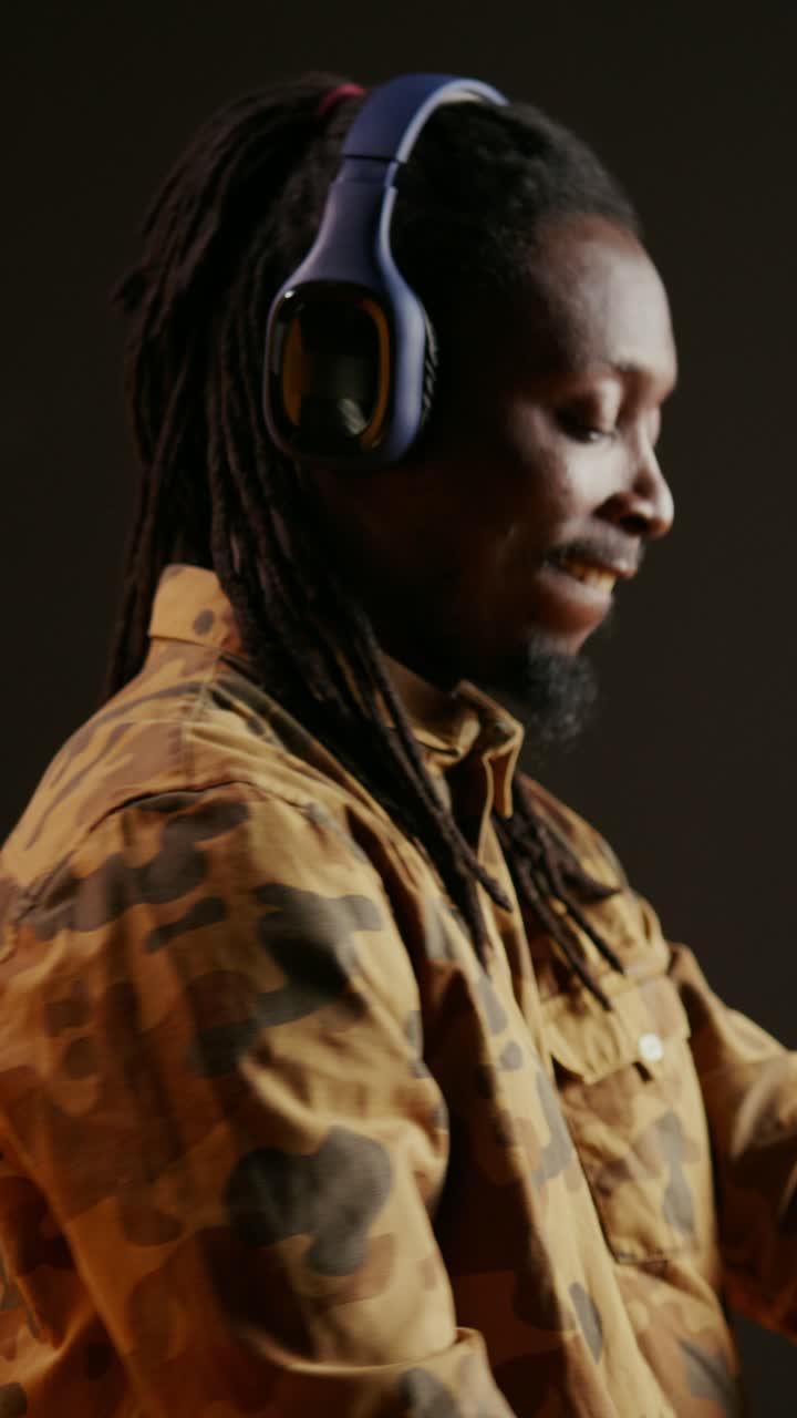 Video verticale: ragazzo afroamericano ascolta musica coinvolgente con le cuffie