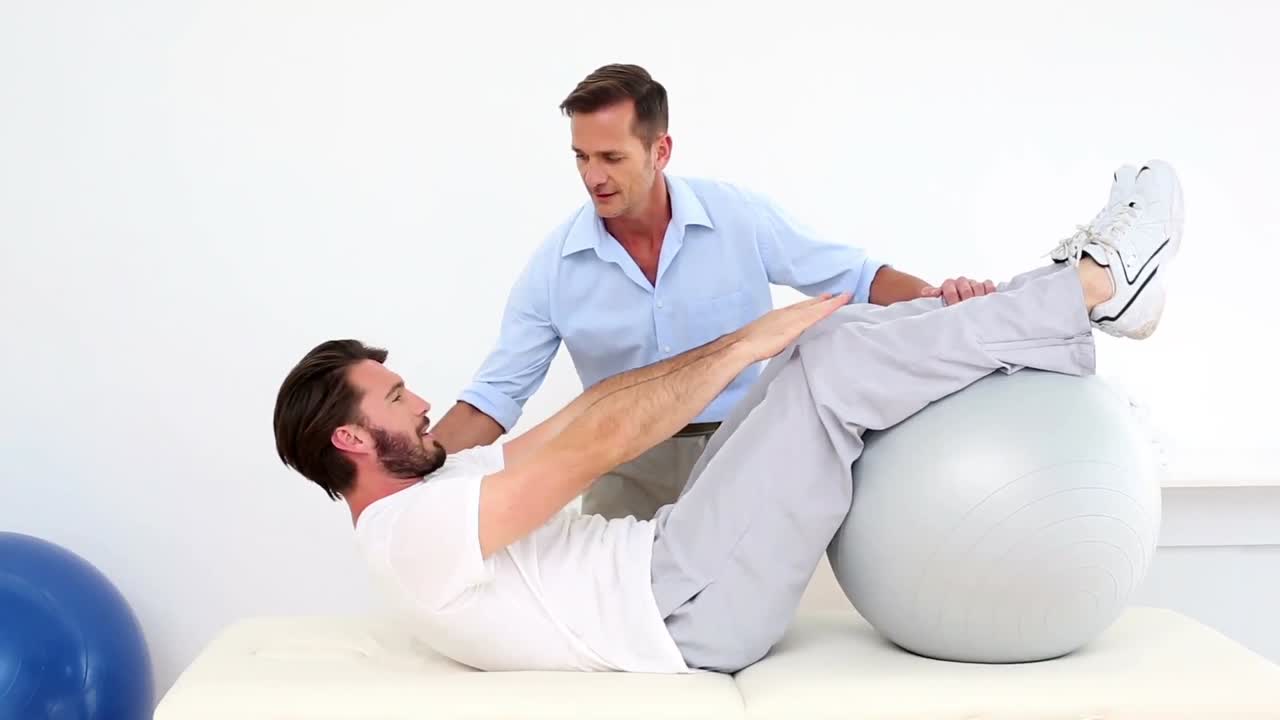 fisioterapeuta ayudando a su paciente a hacer una sentada