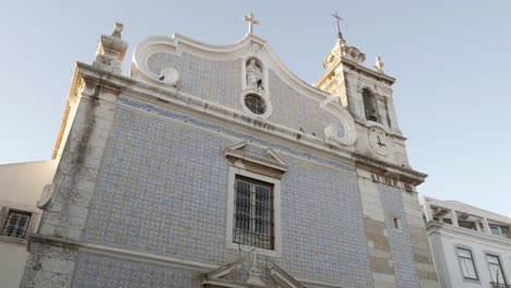 small town church facade with tiles on a sunny day, seixal - portugal