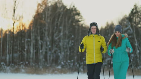 Liebevolle-Kerle-Und-Mädchen,-Die-In-Zeitlupe-Im-Winterwald-Ski-Fahren,-Lächeln-Und-Einander-Anschauen