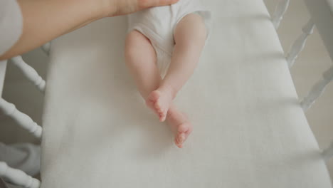 los pies del bebé en una cuna