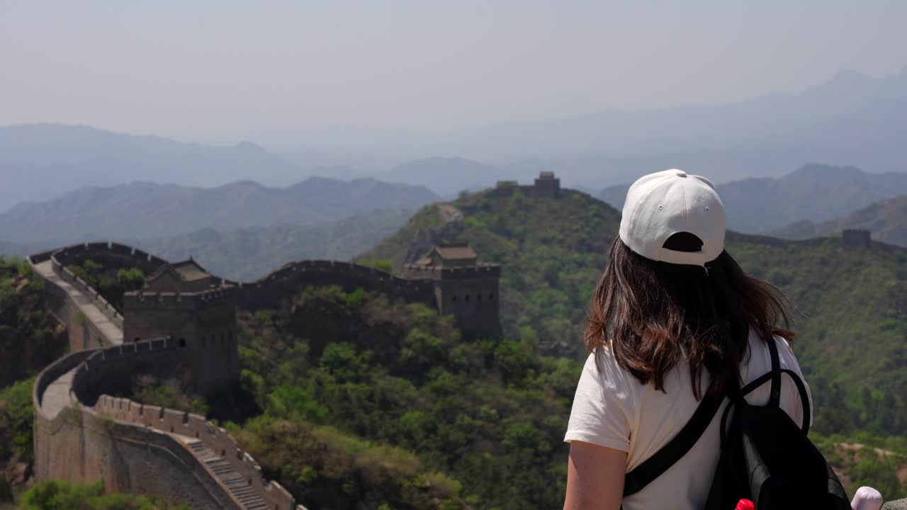 turista mujer excursionista admirando la gran muralla china desde una colina. estática