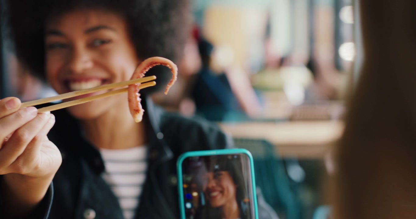 Young Woman Holding Octopus Tentacle with Chopsticks for Photo