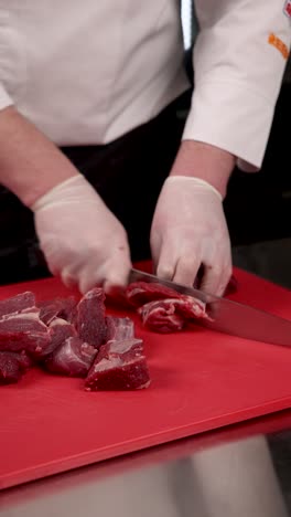 chef cutting raw beef