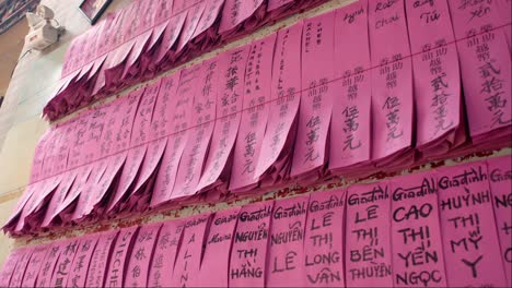 rows of pink prayer candles with chinese inscriptions at jade emperor pagoda in saigon