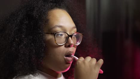 Black-lady-brushing-her-teeth-in-her-bathroom