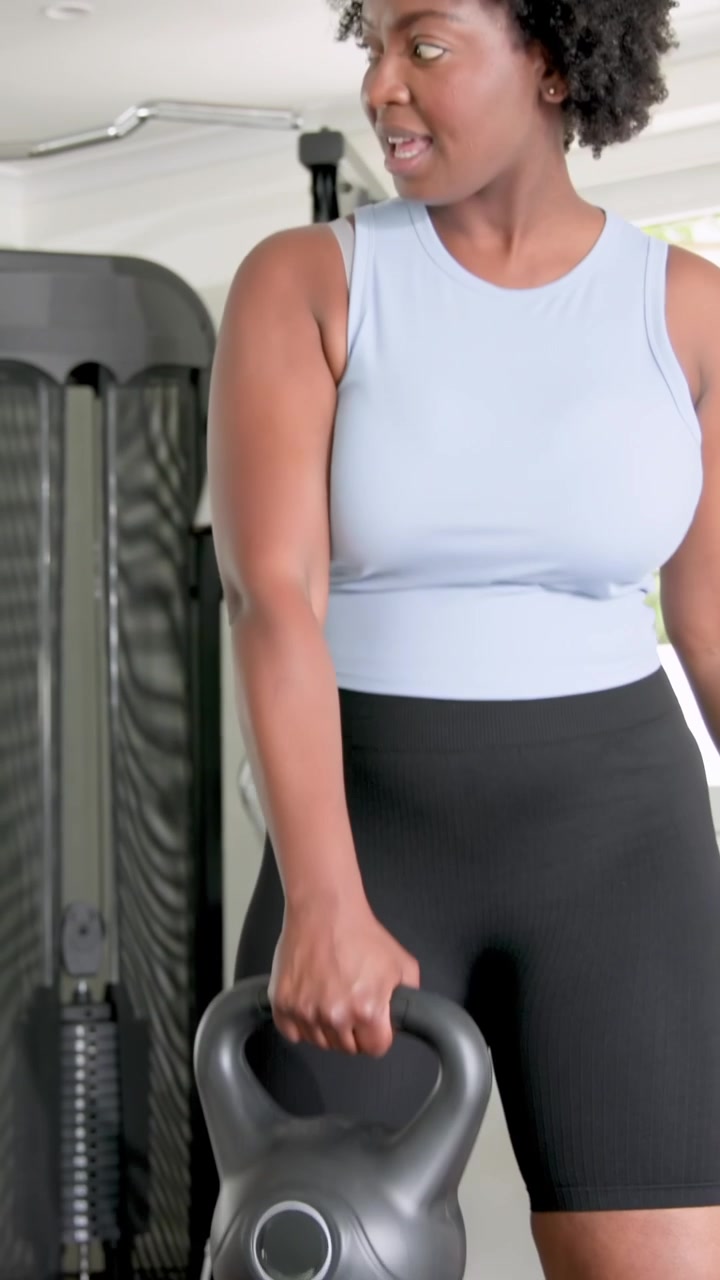 Video verticale: Donne diverse che si scambiano una stretta di mano, regolano l'impugnatura e si allenano a sollevare un kettlebell a casa.
