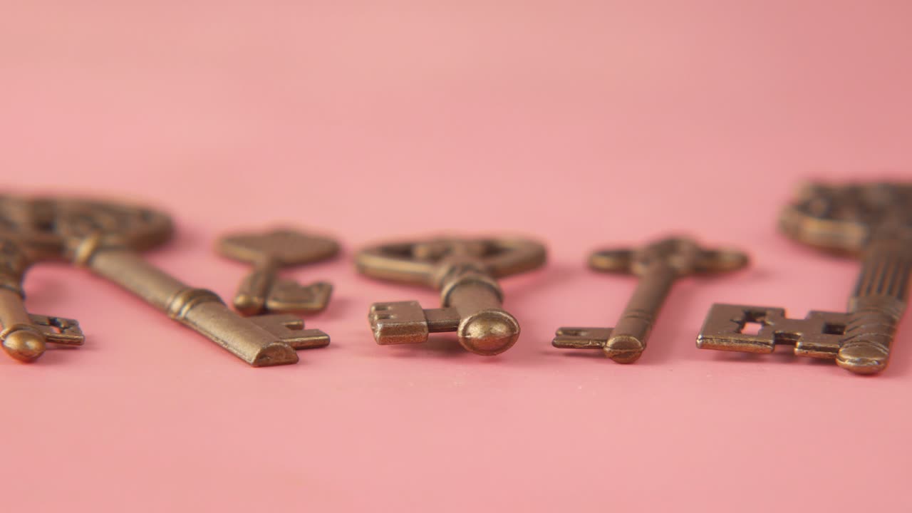 античные золотые ключи на розовом фоне