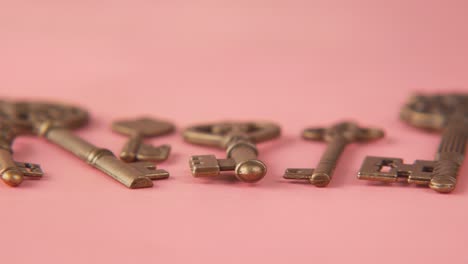 antique gold keys on a pink background